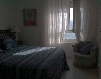 Bedroom with window dresses to the sea